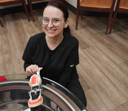 Las Vegas DAS student smiling while working on a temporary crown model during lab practice